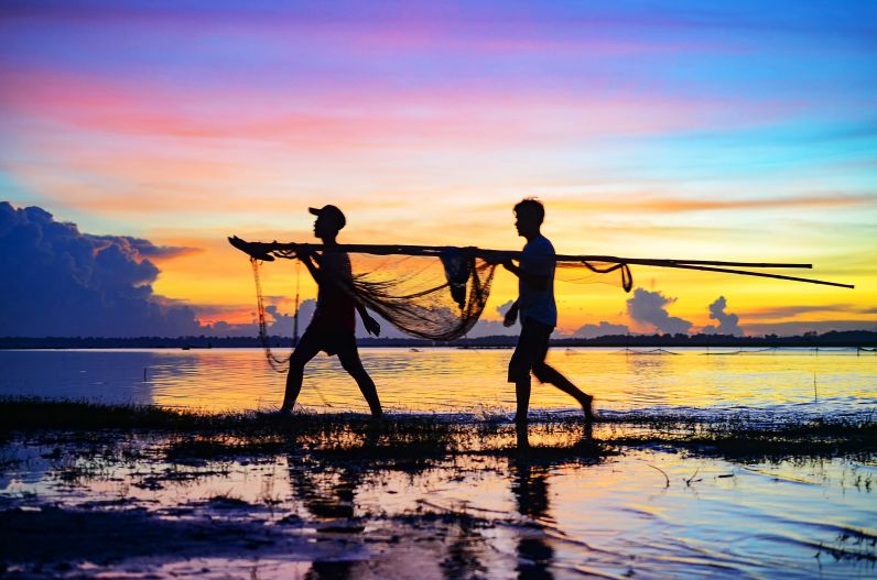 Men working at sunset on Mekong in Prey Veng, Cambodia.
