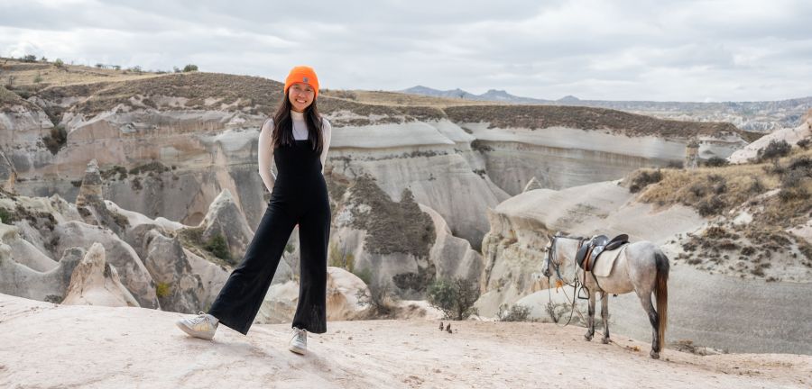 萨凡娜·林（Savanna Lim）参观土耳其城市卡帕多西亚（Cappadocia），在一匹马附近摆姿势拍照。 