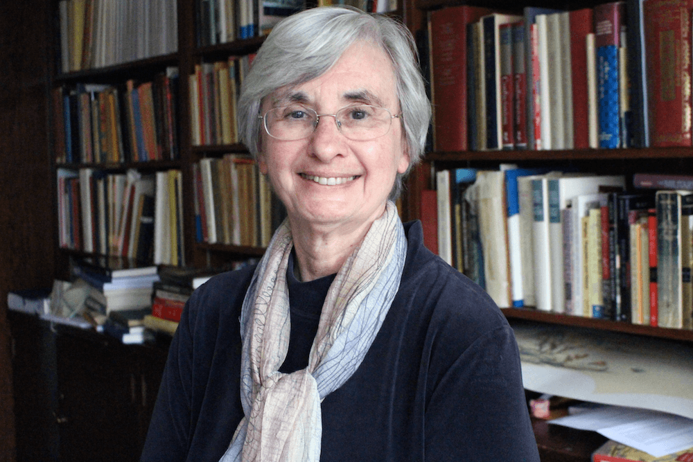 Professor Patricia Ebrey smiles standing in front of book shelf