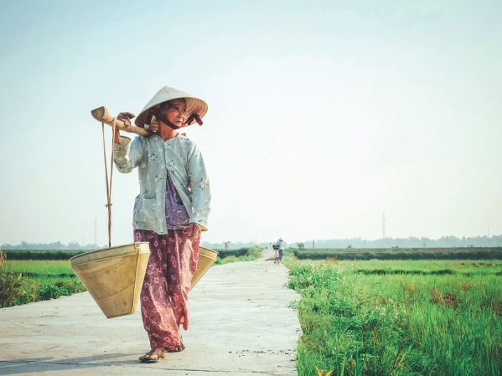 woman in Vietnam walking with baskets