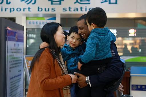 A biracial family hug one another in China