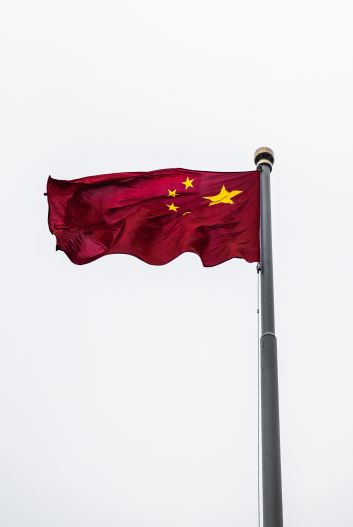 Flag of China against a white sky