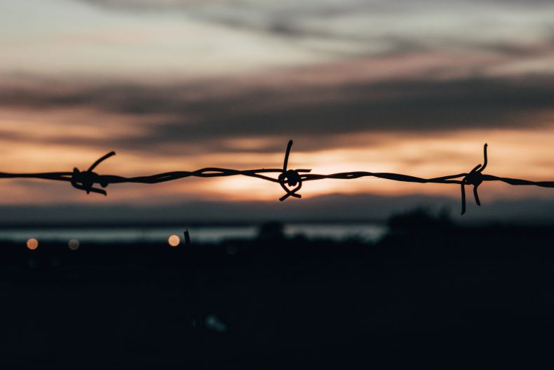 orange sunset through barbed wire
