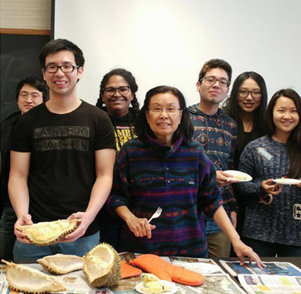 Thai instructor Ngampit with her Thai class eating a durian
