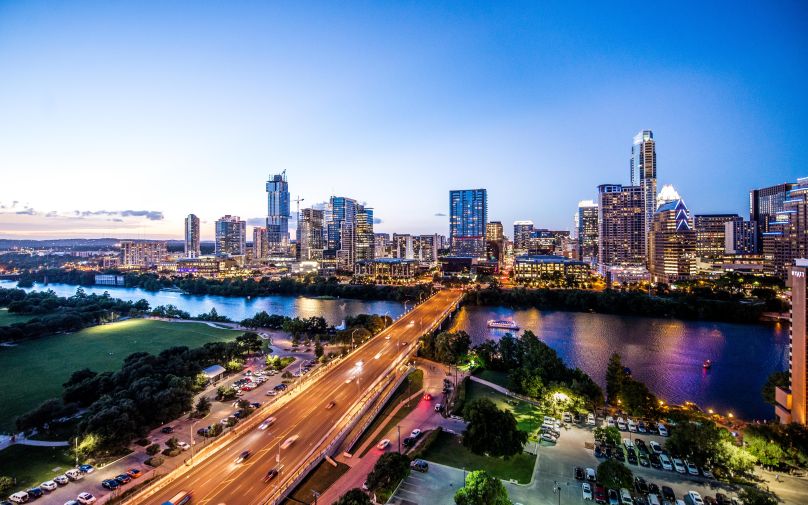 Austin, Texas city skyline at dusk with Congress Avenue Bridge in foreground