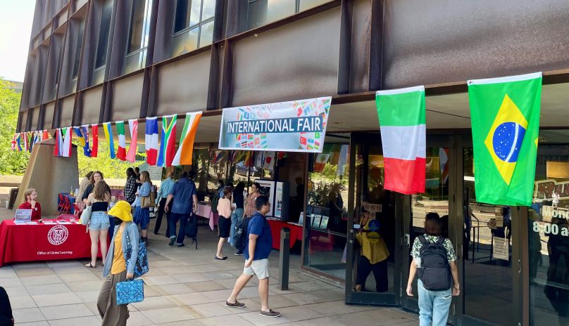 International Fair signs hang over Uris Hall terrace.