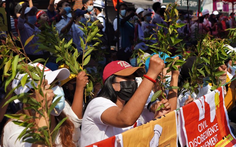 People holding signs and holding their fists in the air at a picket line.