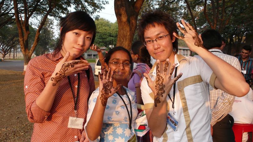 Three students in India with henna on their hands