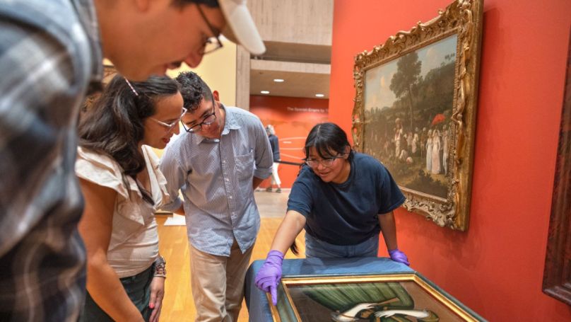 Ananda Cohen-Aponte, associate professor of history of art and visual studies (center left), discusses a painting with Miguel Barrera ’24 (left), Osiel Aldaba ’26 and Emily Hernandez ’25.