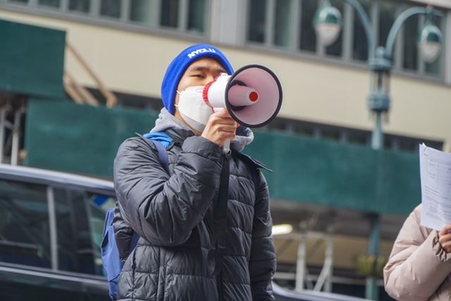 Jonathan Lam speaks into a megaphone