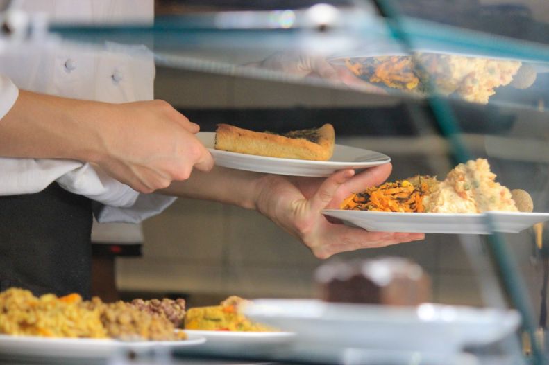 Hands with dishes of food