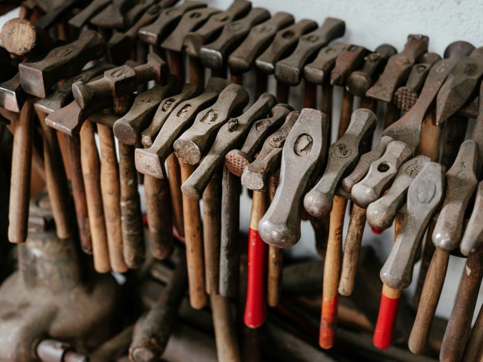 A photo of a rack of hammers, of various sizes. 