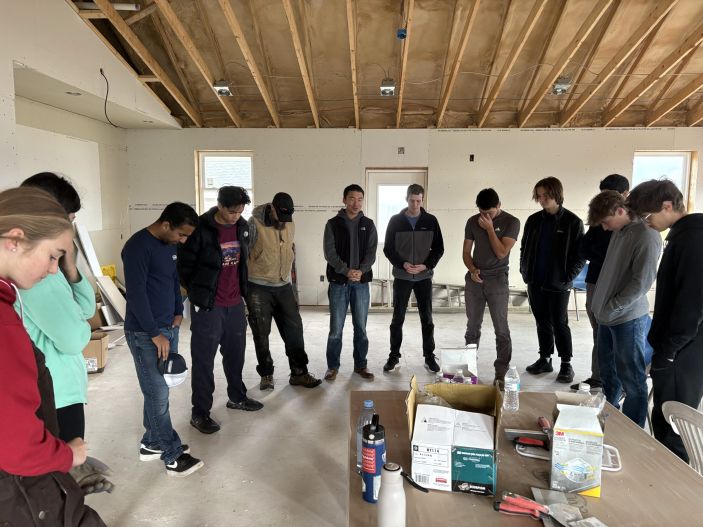 Frank Fang ’26 and students from CRU Cornell gathered in prayer at the Second Wind Cottages Community Center before a day of work.