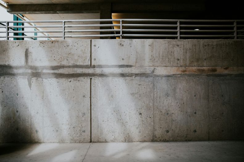 Concrete wall with rails in parking garage