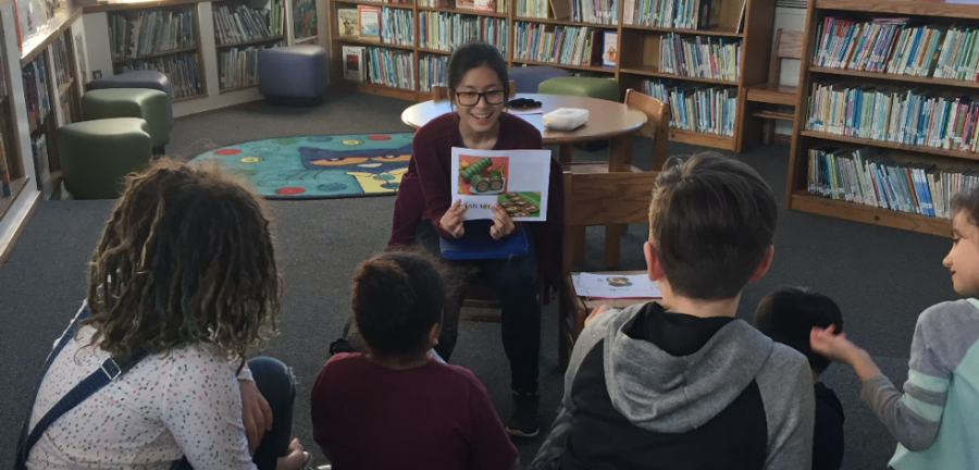 Volunteer reading book to students