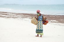 African woman with child walking on beach