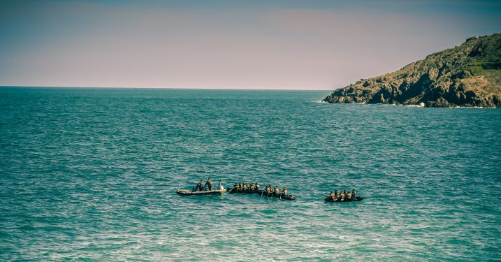People in small boats float in the ocean