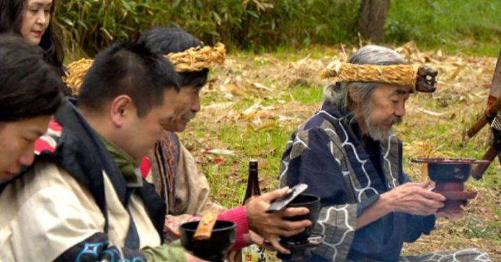 An Ainu elderly man offering tea in a ceremony in Japan