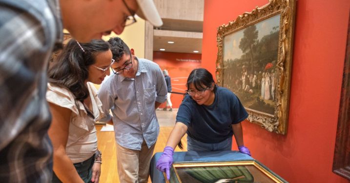 Ananda Cohen-Aponte, associate professor of history of art and visual studies (center left), discusses a painting with Miguel Barrera ’24 (left), Osiel Aldaba ’26 and Emily Hernandez ’25.