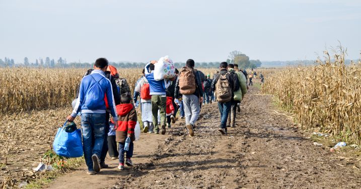 Group of people walking along a dirt path.