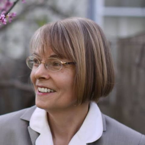 Portrait of Professor Michael Nylan, older white female, dark blonde bob hairstyle, wears glasses, smiles, gray suit jacket white blouse