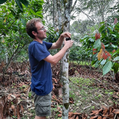Charlie Tebbutt holds up a recorder in the Colombian Amazon.