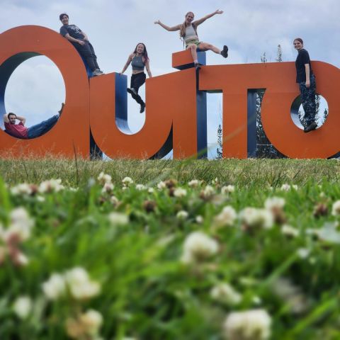 Students pose for a goofy photo by a "Quito" sign.