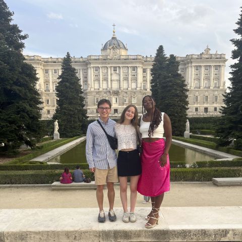 Interns pose for a photo in front of a Spanish palace.