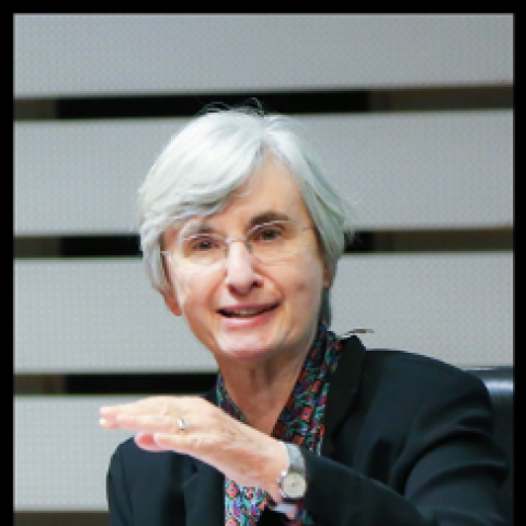 Professor Patricia Ebrey gestures during a lecture. She's an older white female with short silvery hair, wears glasses, is animated and smiles.