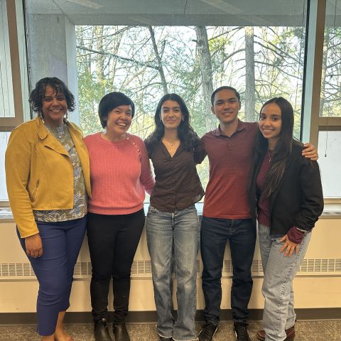 Scholars stand with event speakers.