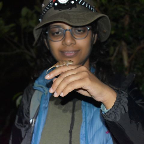 Udita Bansal holds a salamander up on her hand. 