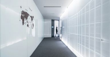 Person walking in a hallway with a map on the wall